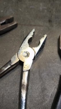 Dikey yüksek çözünürlüklü video. Paslı pense çifti, pasın dokusunu ve aracın üzerindeki aşınmayı gösteren detaylı görünüm, yaşlanmayla ilgili görsel bağlamlar için ideal.