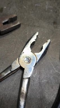 Dikey yüksek çözünürlüklü video. Paslı pense çifti, pasın dokusunu ve aracın üzerindeki aşınmayı gösteren detaylı görünüm, yaşlanmayla ilgili görsel bağlamlar için ideal.