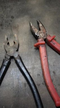 Dikey yüksek çözünürlüklü video. Paslı pense çifti, pasın dokusunu ve aracın üzerindeki aşınmayı gösteren detaylı görünüm, yaşlanmayla ilgili görsel bağlamlar için ideal.
