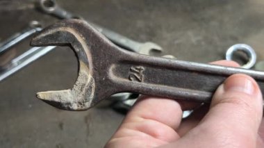 Eski İngiliz anahtarı. Kollu başlıklar, gevşetmek ve fındıkları sıkmak için aletler. Pasla kaplı eski anahtarlar. İzole edilmiş beyaza Dolly vurdu. Anahtarlar ahşap bir yüzeye serilmişti.