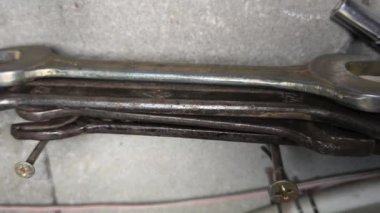 Eski İngiliz anahtarı. Kollu başlıklar, gevşetmek ve fındıkları sıkmak için aletler. Pasla kaplı eski anahtarlar. İzole edilmiş beyaza Dolly vurdu. Anahtarlar ahşap bir yüzeye serilmişti.