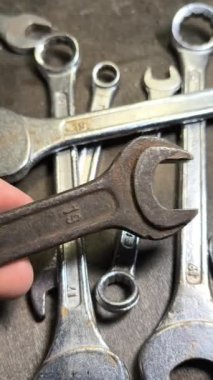 Eski İngiliz anahtarı. Kollu başlıklar, gevşetmek ve fındıkları sıkmak için aletler. Pasla kaplı eski anahtarlar. İzole edilmiş beyaza Dolly vurdu. yüksek tanımlı dikey video.