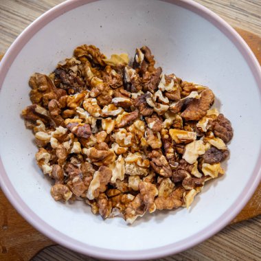 Cevizler yavaş çekim videosu. Bütün ceviz parçaları beyaz masanın üstüne düşüp yavaş çekimde yere düşmeden önce etrafta zıplıyor. Bir Avuç Ceviz Düz Mutfak Yüzeyine Düşüyor