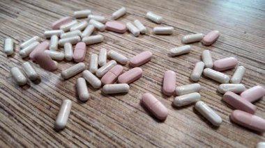 Farklı haplar, yavaş yavaş. Farklı şekillerde renkli haplar düşüyor. Şeffaf bir arkaplanda uyuşturucu düşmesi. İlaç işi konsepti. İlaç kapsülleri arka plan. Eczacılık konsepti.