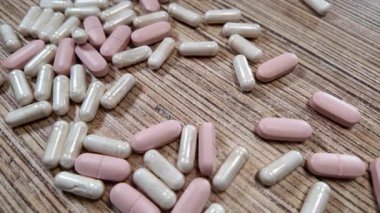 Farklı haplar, yavaş yavaş. Farklı şekillerde renkli haplar düşüyor. Şeffaf bir arkaplanda uyuşturucu düşmesi. İlaç işi konsepti. İlaç kapsülleri arka plan. Eczacılık konsepti.