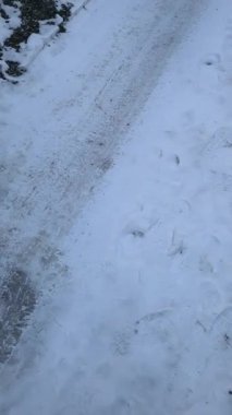 Yoldaki dikey buz videosu. Donmuş yol. Kalın buzlar yolda eriyor..