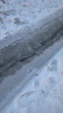 Yoldaki dikey buz videosu. Donmuş yol. Kalın buzlar yolda eriyor..