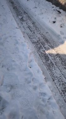 Yoldaki dikey buz videosu. Donmuş yol. Kalın buzlar yolda eriyor..