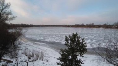 Nehirdeki buz. İlkbaharda buz yavaşça nehirde yüzüyor. Yüzen donmuş buz blokları olan nehir. Kıyıdaki karlar ve ağaçlar donuyor. Nehirdeki buz. Donmuş nehirde yürü. 4k video