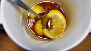 Siyah çay ve limon yavaş çekim videosu. Bardakta çay. bir fincan çayın içinde yüzen limon.