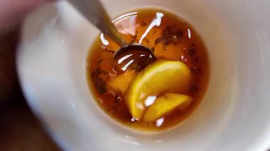 Siyah çay ve limon yavaş çekim videosu. Bardakta çay. bir fincan çayın içinde yüzen limon.