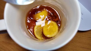 Siyah çay ve limon yavaş çekim videosu. Bardakta çay. bir fincan çayın içinde yüzen limon.