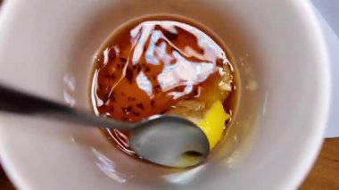 Siyah çay ve limon yavaş çekim videosu. Bardakta çay. bir fincan çayın içinde yüzen limon.