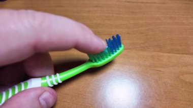 Ellerinde yeşil diş fırçası. Diş fırçasıyla yavaş çekim videosu. Diş fırçası. çok renkli diş fırçaları. Yavaş çekim videosu. 4K biçiminde yüksek kaliteli video.