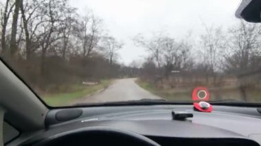 Sürücü birinci şahıstan geliyor. Birinci şahıs video sürücüsü. Araba kontrolü. Kötü yol ve arabada yağmur. Kötü havada araba yolculuğu. Yoldaki çukurlar.