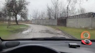 Sürücü birinci şahıstan geliyor. Birinci şahıs video sürücüsü. Araba kontrolü. Kötü yol ve arabada yağmur. Kötü havada araba yolculuğu. Yoldaki çukurlar.