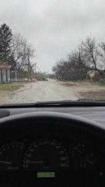 Sürücü birinci şahıstan geliyor. Birinci şahıs video sürücüsü. Araba kontrolü. Kötü yol ve arabada yağmur. Kötü havada araba yolculuğu. Yoldaki çukurlar.