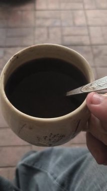 Ellerinde güzel bir fincan kahve. Sıra dışı bardak. Bir fincan kil çay. Kahve içen bir adam. Çay içen adam. canlı kamera.