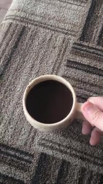 Ellerinde güzel bir fincan kahve. Sıra dışı bardak. Bir fincan kil çay. Kahve içen bir adam. Çay içen adam. canlı kamera.