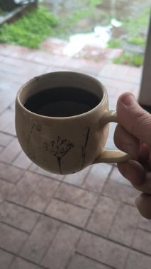 Ellerinde güzel bir fincan kahve. Sıra dışı bardak. Bir fincan kil çay. Kahve içen bir adam. Çay içen adam. canlı kamera.