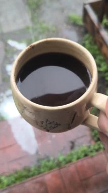 Ellerinde güzel bir fincan kahve. Sıra dışı bardak. Bir fincan kil çay. Kahve içen bir adam. Çay içen adam. canlı kamera.