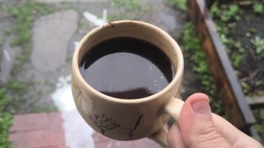 Ellerinde güzel bir fincan kahve. Sıra dışı bardak. Bir fincan kil çay. Kahve içen bir adam. Çay içen adam. canlı kamera.