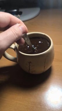 Ellerinde güzel bir fincan kahve. Sıra dışı bardak. Bir fincan kil çay. Kahve içen bir adam. Çay içen adam. canlı kamera.