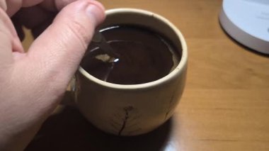 Ellerinde güzel bir fincan kahve. Sıra dışı bardak. Bir fincan kil çay. Kahve içen bir adam. Çay içen adam. canlı kamera.