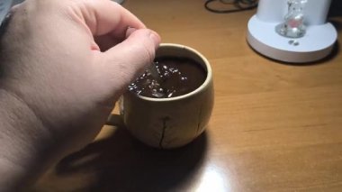 Ellerinde güzel bir fincan kahve. Sıra dışı bardak. Bir fincan kil çay. Kahve içen bir adam. Çay içen adam. canlı kamera.
