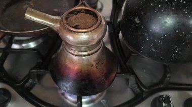 Türk kahvesinin evdeki mutfaktaki metal ocakta hazırlanışının yakın çekim görüntüleri..
