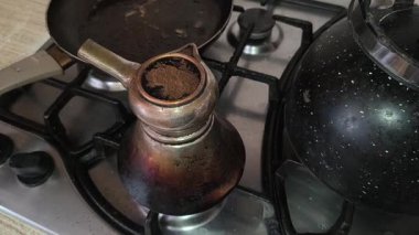 Türk kahvesinin evdeki mutfaktaki metal ocakta hazırlanışının yakın çekim görüntüleri..