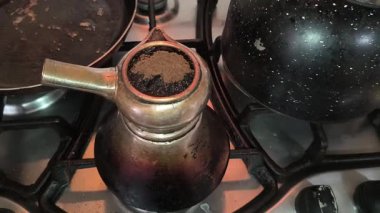 Türk kahvesinin evdeki mutfaktaki metal ocakta hazırlanışının yakın çekim görüntüleri..