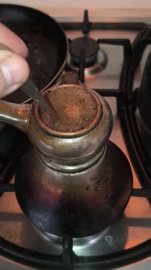 Türk kahvesinin evdeki mutfaktaki metal ocakta hazırlanışının yakın çekim görüntüleri..