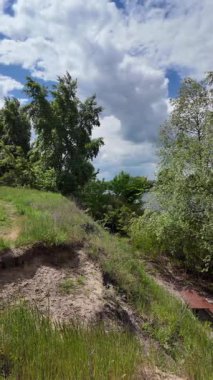 Nehir ve kasvetli gökyüzü manzarası. Yavaş çekim video doğa manzarası. Yağmurdan önce hava durumu. Fırtınadan önce gökyüzü. Güneş ve yoğun yağmur bulutları. Nehir ve kumlu sahil. Nehirde karanlık su.