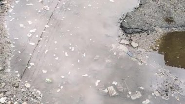 Yansımalı su birikintisi. Su birikintisindeki yansıma. Yağmur damlaları şehrin kaldırımlarına ışık yansıyan su birikintisinin üzerine düşüyor, yağmur gece, hava veya çevre ışıklarıyla düşüyor, hiç kimse