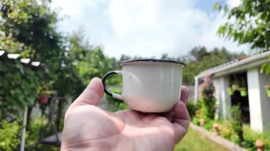 Klasik metal bardak. Bir el, Endonezya 'dan yeşil ekran arka planlı geleneksel bir yeşil metal bardak tutuyor. Yavaş çekim video bardağı elinde.