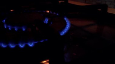 Gaz ocağında benzin yanıyor. Yanan gazın mavi alevi. Mutfak ocağını karanlıkta tutuşturmak. Yakıtı kapat ve mavi alevle tutuştur. Ev yapımı fırın açılıp kapanıyor