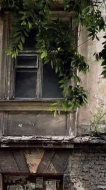 Harap olmuş bir evde eski bir pencere. Duvardaki eski kırık ahşap pencere. Çatlak bir evin duvarı. Terk edilmiş ev.