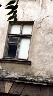 Harap olmuş bir evde eski bir pencere. Duvardaki eski kırık ahşap pencere. Çatlak bir evin duvarı. Terk edilmiş ev.