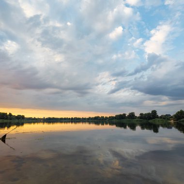Çok güzel bir gün batımı ve su. Yaz akşamı manzarası. Sudaki bulutların yansıması. Güneş ufukta batıyor. Göllü yaz manzarası. Sudaki ağaçların yansıması. Nehirde gün doğumu. şehvetli bulutlar.
