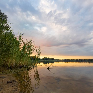 Çok güzel bir gün batımı ve su. Yaz akşamı manzarası. Sudaki bulutların yansıması. Güneş ufukta batıyor. Göllü yaz manzarası. Sudaki ağaçların yansıması. Nehirde gün doğumu. şehvetli bulutlar.