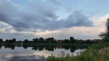 Çok güzel bir gün batımı ve su. Yaz akşamı manzarası. Sudaki bulutların yansıması. Güneş ufukta batıyor. Göllü yaz manzarası. Sudaki ağaçların yansıması. Nehirde gün doğumu. şehvetli bulutlar.