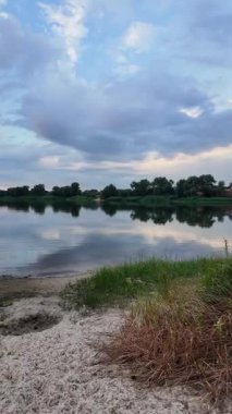 Çok güzel bir gün batımı ve su. Yaz akşamı manzarası. Sudaki bulutların yansıması. Güneş ufukta batıyor. Göllü yaz manzarası. Sudaki ağaçların yansıması. Nehirde gün doğumu. şehvetli bulutlar.