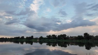 Çok güzel bir gün batımı ve su. Yaz akşamı manzarası. Sudaki bulutların yansıması. Güneş ufukta batıyor. Göllü yaz manzarası. Sudaki ağaçların yansıması. Nehirde gün doğumu. şehvetli bulutlar.