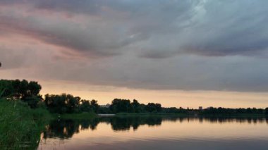 Çok güzel bir gün batımı ve su. Yaz akşamı manzarası. Sudaki bulutların yansıması. Güneş ufukta batıyor. Göllü yaz manzarası. Sudaki ağaçların yansıması. Nehirde gün doğumu. şehvetli bulutlar.