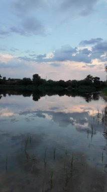 Çok güzel bir gün batımı ve su. Yaz akşamı manzarası. Sudaki bulutların yansıması. Güneş ufukta batıyor. Göllü yaz manzarası. Sudaki ağaçların yansıması. Nehirde gün doğumu. şehvetli bulutlar.