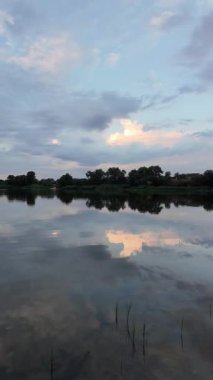 Çok güzel bir gün batımı ve su. Yaz akşamı manzarası. Sudaki bulutların yansıması. Güneş ufukta batıyor. Göllü yaz manzarası. Sudaki ağaçların yansıması. Nehirde gün doğumu. şehvetli bulutlar.