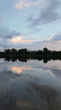 Çok güzel bir gün batımı ve su. Yaz akşamı manzarası. Sudaki bulutların yansıması. Güneş ufukta batıyor. Göllü yaz manzarası. Sudaki ağaçların yansıması. Nehirde gün doğumu. şehvetli bulutlar.