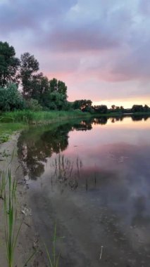 Çok güzel bir gün batımı ve su. Yaz akşamı manzarası. Sudaki bulutların yansıması. Güneş ufukta batıyor. Göllü yaz manzarası. Sudaki ağaçların yansıması. Nehirde gün doğumu. şehvetli bulutlar.