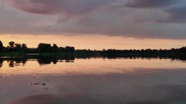 Çok güzel bir gün batımı ve su. Yaz akşamı manzarası. Sudaki bulutların yansıması. Güneş ufukta batıyor. Göllü yaz manzarası. Sudaki ağaçların yansıması. Nehirde gün doğumu. şehvetli bulutlar.
